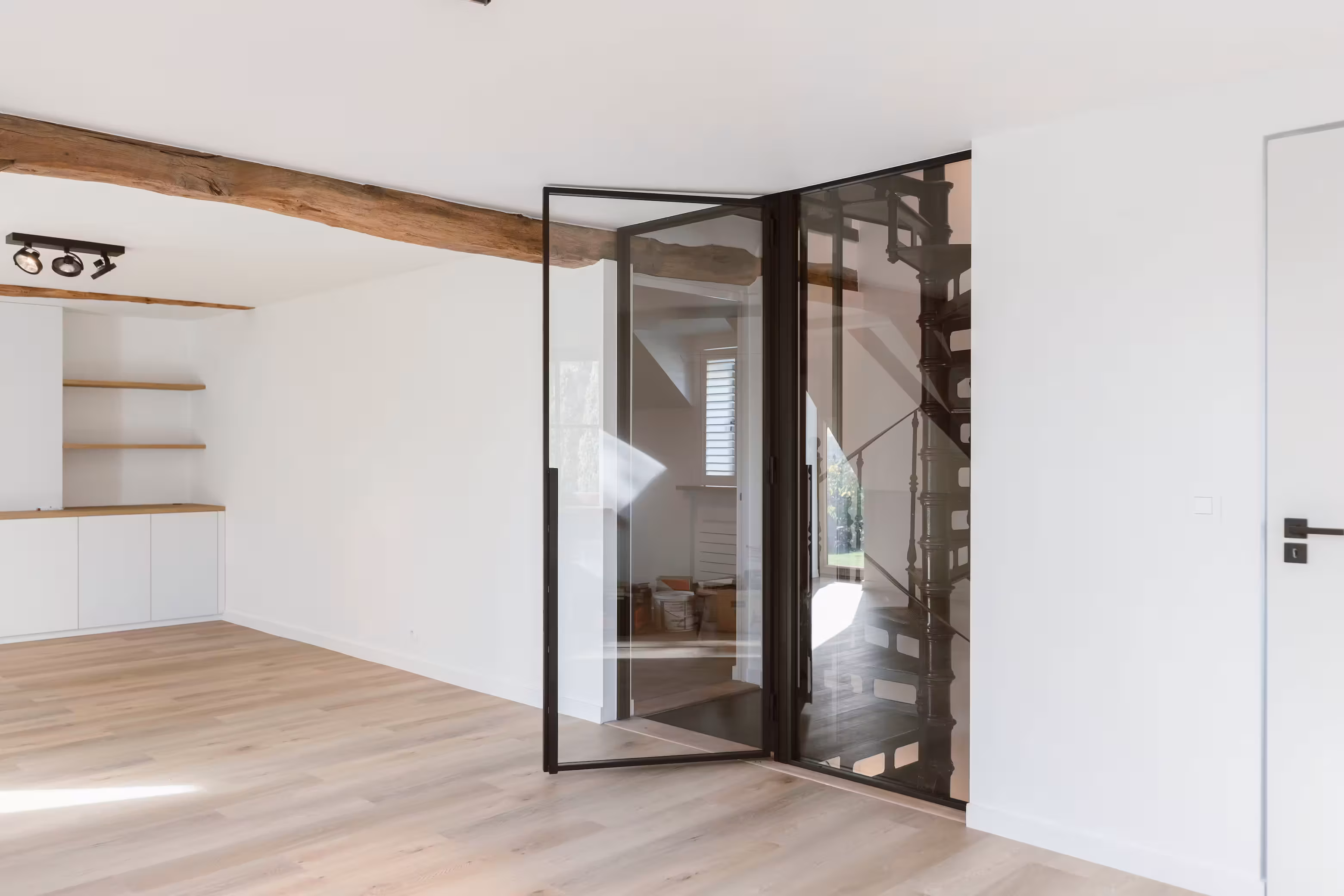 Lichte hal met een zwart stalen deur naar de woonkamer