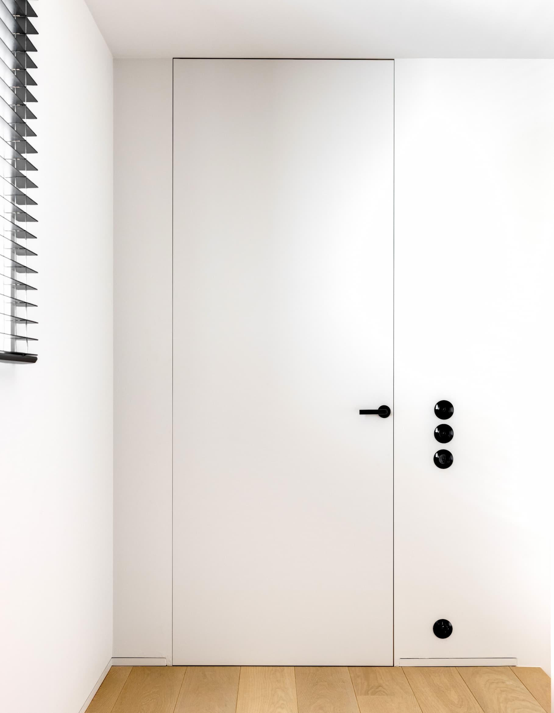 Vlakdeur van Xinnix met zwarte deurklink en magneetslot